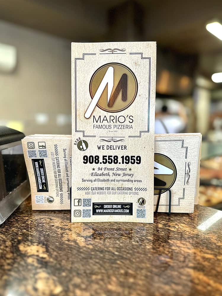 A business card for marco's pizza sitting on a counter.